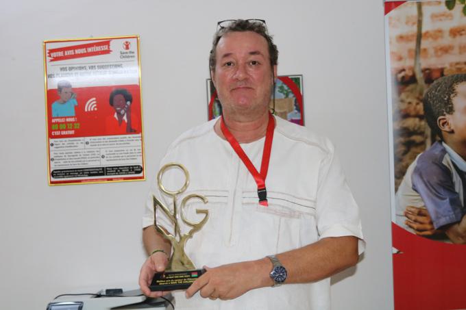 Benoît Delsarte, Directeur pays de Save the Children Burkina, posant avec le trophée du meilleur prix secteur de l'éducation